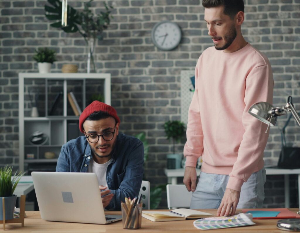 Young professionals collaborating in a modern office space, engaging in a project discussion.